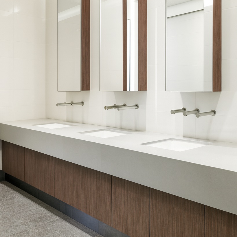 Handwashing signage near automatic soap dispenser in office restroom