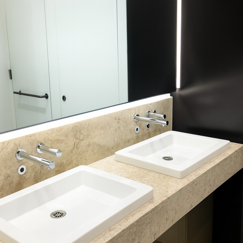 Open-plan office floor with circulation towards core restrooms